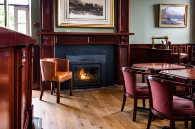 a fireplace in a restaurant with chairs and a fire place at The Inveraray Inn, BW Signature Collection in Inveraray
