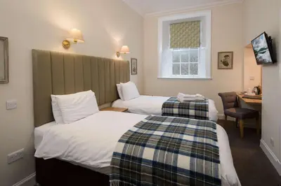 a hotel room with two beds and a desk at The Inveraray Inn, BW Signature Collection in Inveraray