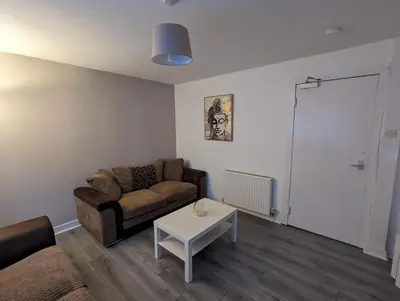 a living room with a couch and a table at 4 bedroom Townhouse Greenock in Greenock