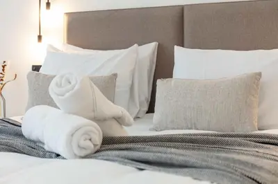 a bed with white towels on top of it at Wellington Lodge in Ayr