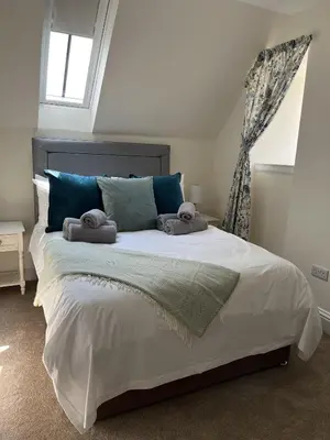 a bedroom with a large bed with towels on it at The Farmhouse at Solsgirth Home Farm in Dollar