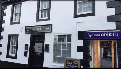 a white building with signs on the side of it at Blackbull With Rooms Lower in Cumbernauld