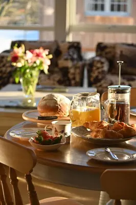 a table with plates of food and drinks on it at Merlin Steading with hot tub in Buchanty