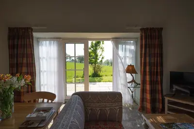 a living room with a couch and a sliding glass door at The Bothy in Buchanty