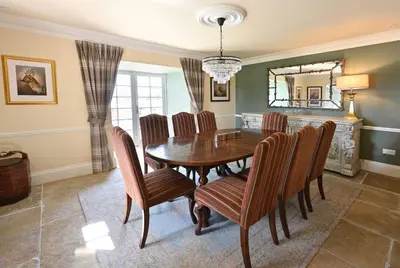 a dining room with a wooden table and chairs at Milton Farm in Buchanty