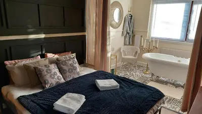 a bedroom with a bed and a tub and a sink at Luxurious room with a private bathtub and shared toilet and kitchen 10mins from City Centre in Bailleston