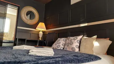 a bedroom with a large bed with a mirror at Luxurious room with a private bathtub and shared toilet and kitchen 10mins from City Centre in Bailleston