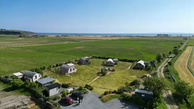 an aerial view of a farm with a group of tents at The Galloway Steading - The Fox's Den with Hot Tub and Fire Pit in Glenluce
