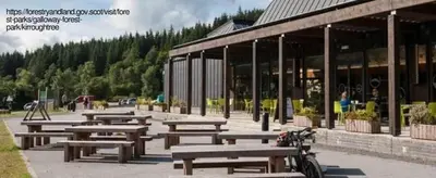 a group of picnic tables in front of a building at The Galloway Steading - The Fox's Den with Hot Tub and Fire Pit in Glenluce