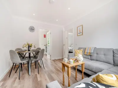 a living room with a couch and a table at Riverbank in Lamlash