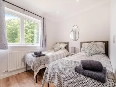 a bedroom with two beds and a window at Riverbank in Lamlash