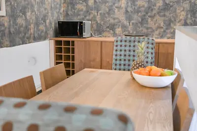 a wooden table with a bowl of fruit on it at The Old School in Dean Village in Edinburgh