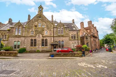 an old building with a red car in front of it at The Old School in Dean Village in Edinburgh