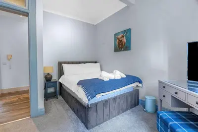 a bedroom with a bed with a blue blanket at GuestReady - Lovely nest in the Old Town in Edinburgh