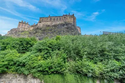 a castle on top of a hill with trees at GuestReady - Lovely nest in the Old Town in Edinburgh