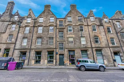 a car parked in front of a large brick building at GuestReady - Lovely nest in the Old Town in Edinburgh