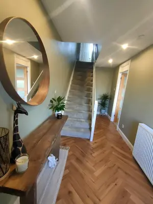 a room with a staircase with a mirror and a stair case at Troon Beach and Golf House in Barassie