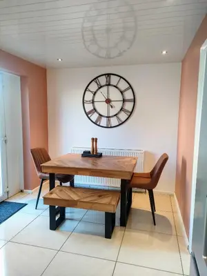 a dining room with a table and a clock on the wall at Troon Beach and Golf House in Barassie