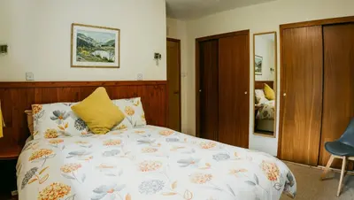 a bedroom with a bed with a floral comforter at Heatheryhaugh Lodges in Moffat