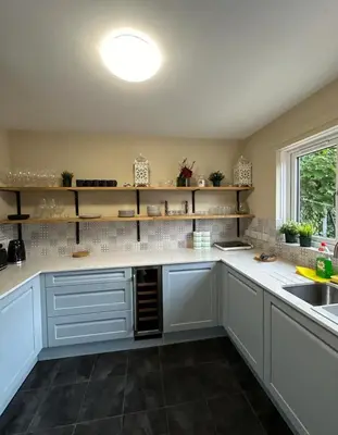 a kitchen with white cabinets and a sink and a window at Beautiful house in Clydebank in Glasgow