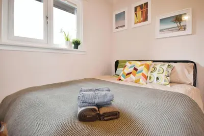 a bedroom with a bed with a towel on it at Beautiful house in Clydebank in Glasgow