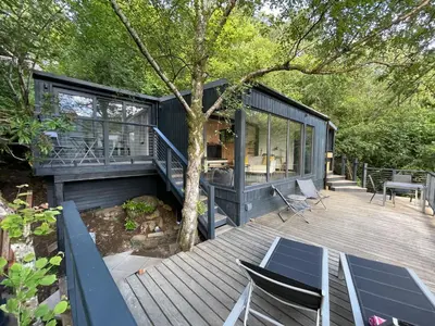 a house with a deck with a table and chairs at Cherrybrae Cottage in Saint Fillans