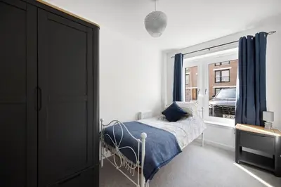 a bedroom with a bed and a window at Dunmore Rooftop in Glasgow