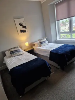 a bedroom with two beds and a window at Star Apartment in Dumbarton