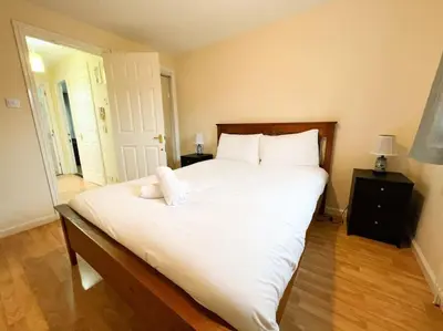 a bedroom with a large white bed with white pillows at Cosy Riverside Home SECC Hydro in Glasgow