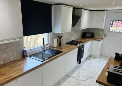 a kitchen with white cabinets and a sink at Glasgow Central Paradise - Spacious 3- Bed House in Glasgow