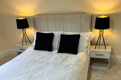a bedroom with a white bed with two lamps at Glasgow Central Paradise - Spacious 3- Bed House in Glasgow