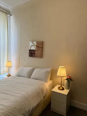 a bedroom with a bed with two lamps and a window at Haymaeket Centro Edinburgh in Edinburgh