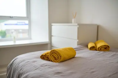 two yellow towels on a bed in a bedroom at Cosy & Comfortable 2BR in Oban - Walk to Waterfront in Oban
