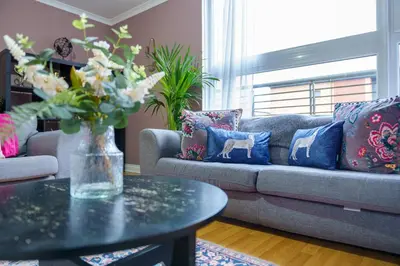 a living room with a couch and a table with pillows at 5 Bed Finnieston SkyHigh Duplex with Parking in Glasgow