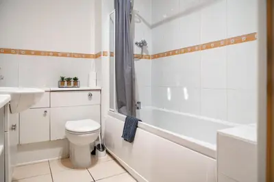 a bathroom with a toilet and a tub and a sink at 5 Bed Finnieston SkyHigh Duplex with Parking in Glasgow