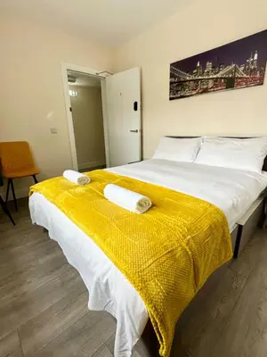 a bedroom with a large bed with a yellow blanket at Edinburgh full house in Edinburgh