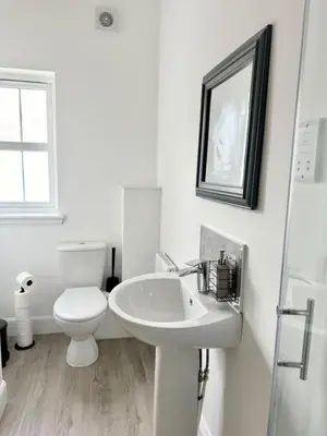 a white bathroom with a toilet and a sink at Edinburgh full house in Edinburgh