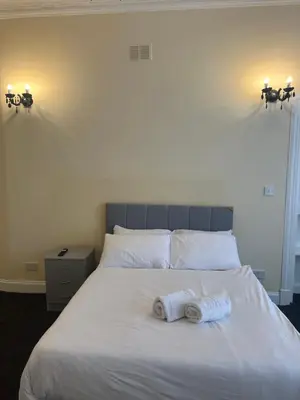 a bedroom with a bed with two towels on it at Glasgow South 2 Bedroom Apartment in Glasgow