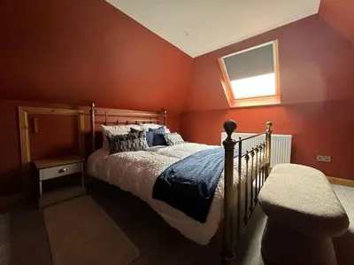 a bedroom with a bed and a window at Stylish House with hot tub in Dalry