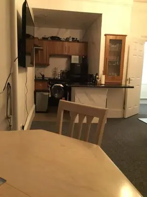 a room with a kitchen with a table and a dining table at Beautiful 2 double bedrooms, 2 baths apartment in Port Glasgow
