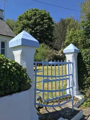a white fence with a blue gate in a yard at Coolranny Schoolhouse in Torr