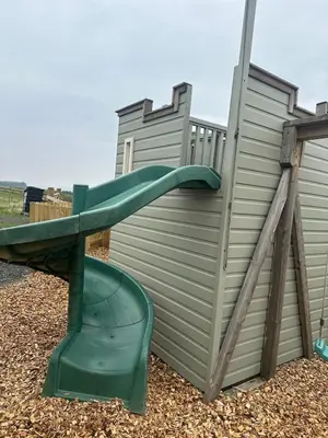 a playground with a green slide on a fence at Firth View 2 - Country Escape with Sea Views of Arran! in Ayr