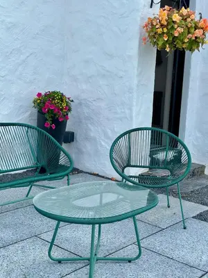 two green chairs and a glass table on a patio at Firth View 2 - Country Escape with Sea Views of Arran! in Ayr