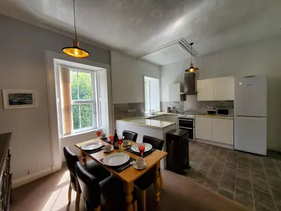 a kitchen with a table and chairs in a room at Little Bay View in Oban