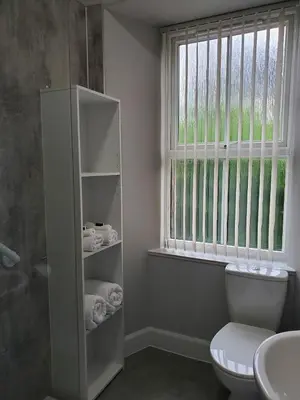 a bathroom with a toilet and a sink and a window at Little Bay View in Oban