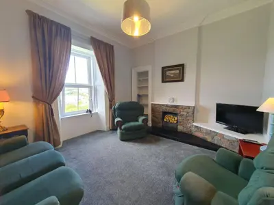a living room with chairs and a fire place at Little Bay View in Oban