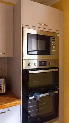a microwave above an oven in a kitchen at The Hill in Tillicoultry