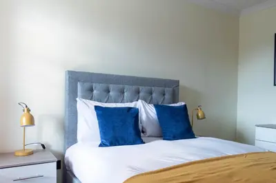 a bedroom with a large bed with blue pillows at The Hill in Tillicoultry