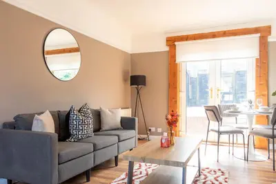 a living room with a couch and a table at Beth House in Bathgate