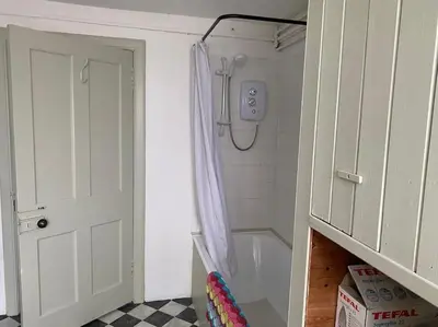 a bathroom with a shower with a shower curtain at The Bothy at Christmas Cottage in Rowardennan